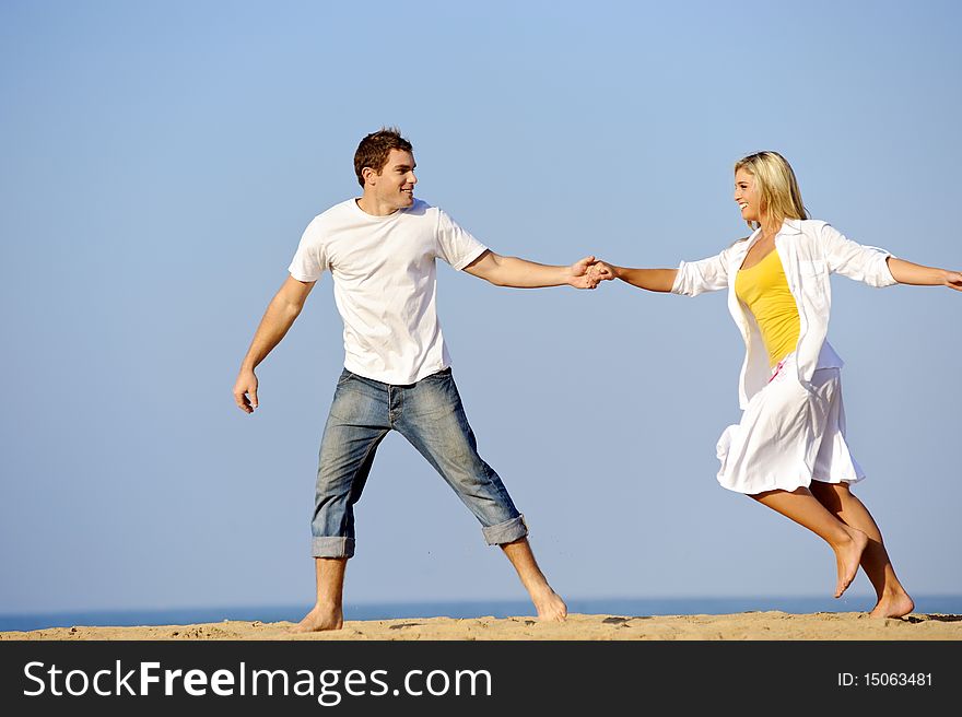 Happy, fresh young couple enjoy a day on the beach together. Happy, fresh young couple enjoy a day on the beach together