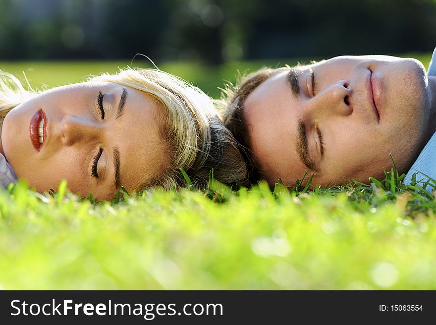 Young couple lying on the grass outside together. Young couple lying on the grass outside together