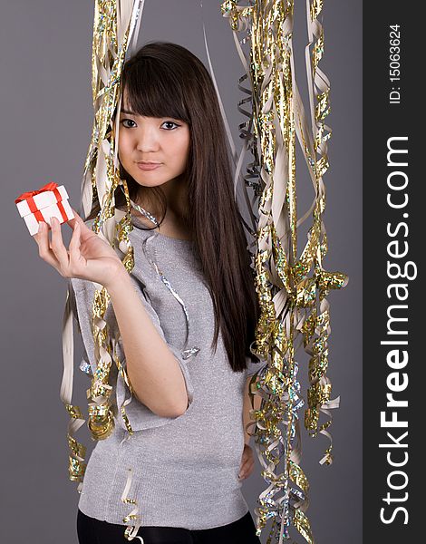 Girl standing among tinsel studio shot