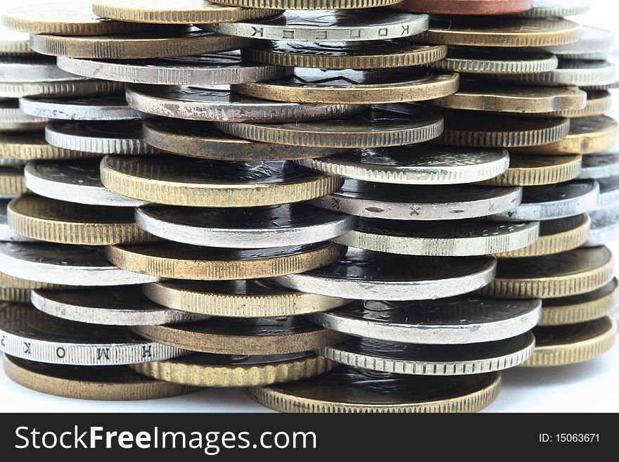 Heap of different metal coins over white