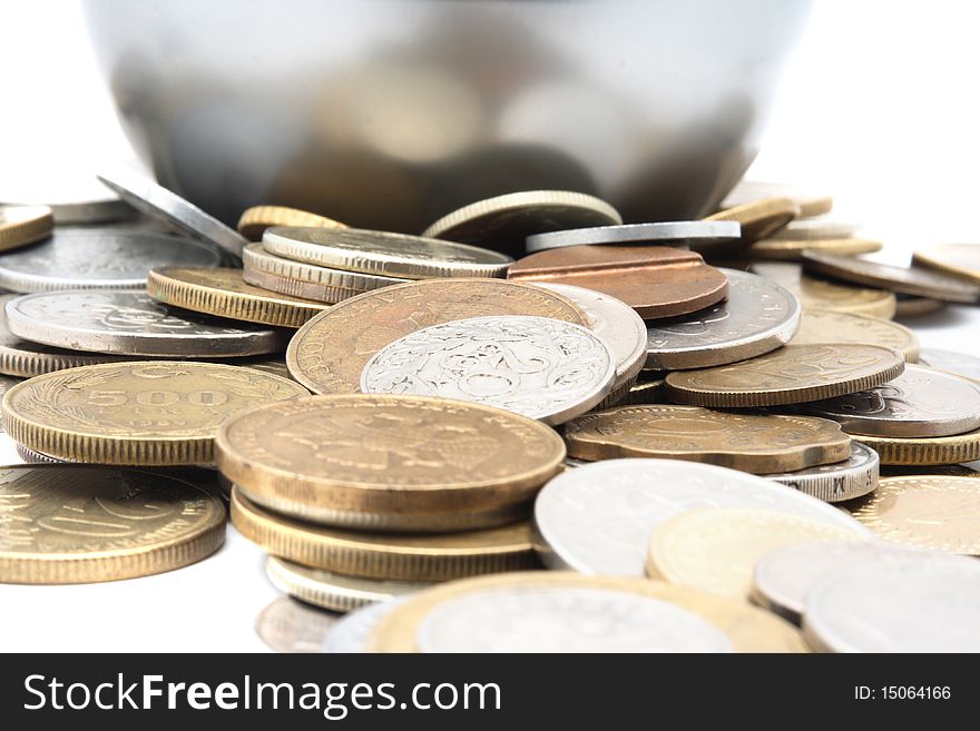 Heap of different metal coins over white