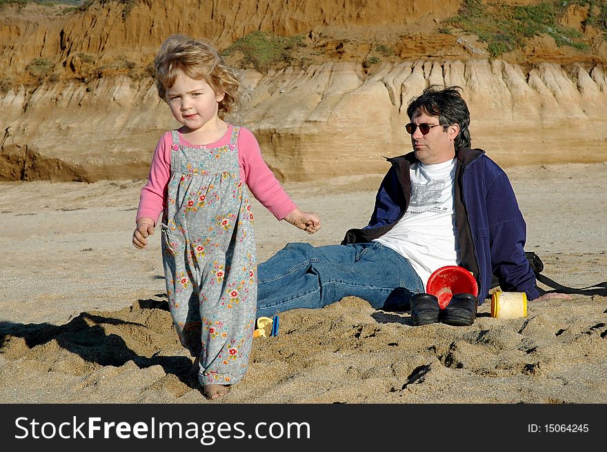 Two year old girl with father on beach. Two year old girl with father on beach