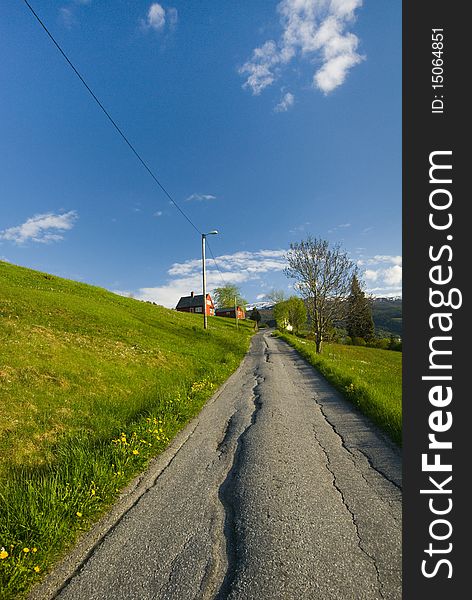 An aged road to the peace full hill village, alongside the grass hill at Vossevangen,  Norway