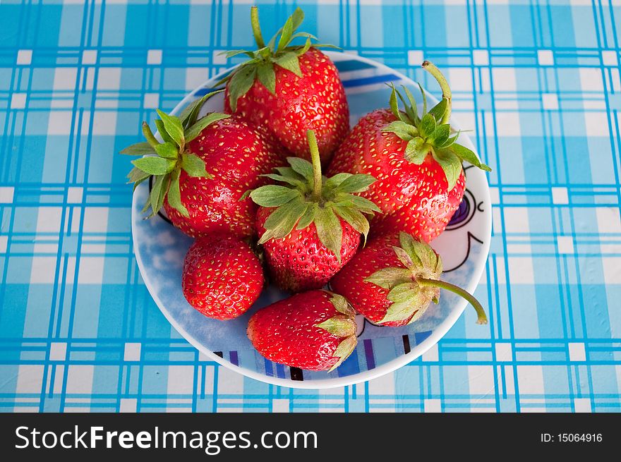 Juicy strawberries on blue plate