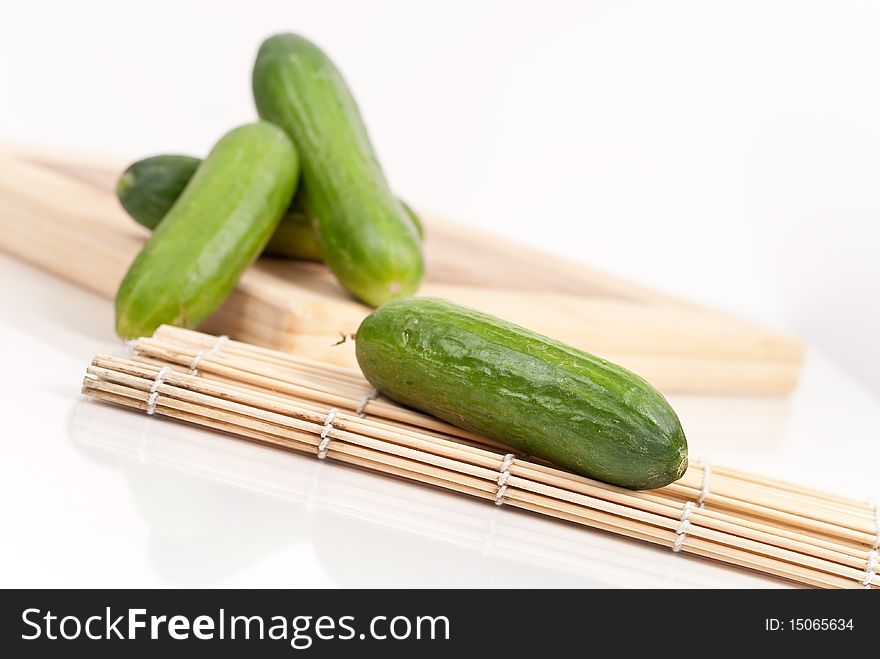 Homegrown cucumbers on a cutting board and a bamboo place-mat. Homegrown cucumbers on a cutting board and a bamboo place-mat.