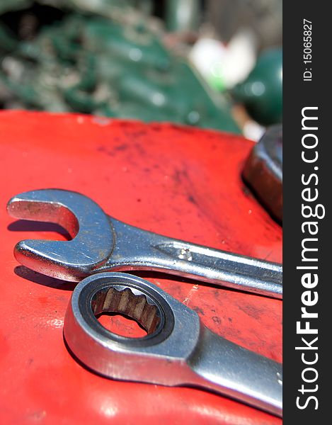 Detail of metal wrenches on old-timer tractor with part of engine. Detail of metal wrenches on old-timer tractor with part of engine