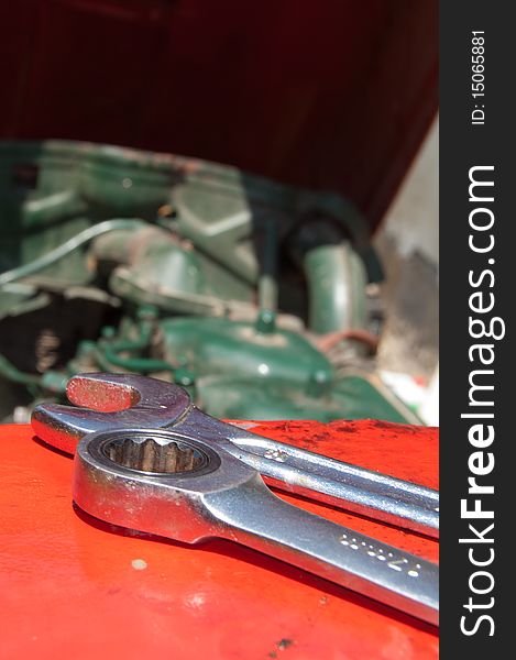 Detail of metal wrenches on old-timer tractor with part of engine. Detail of metal wrenches on old-timer tractor with part of engine