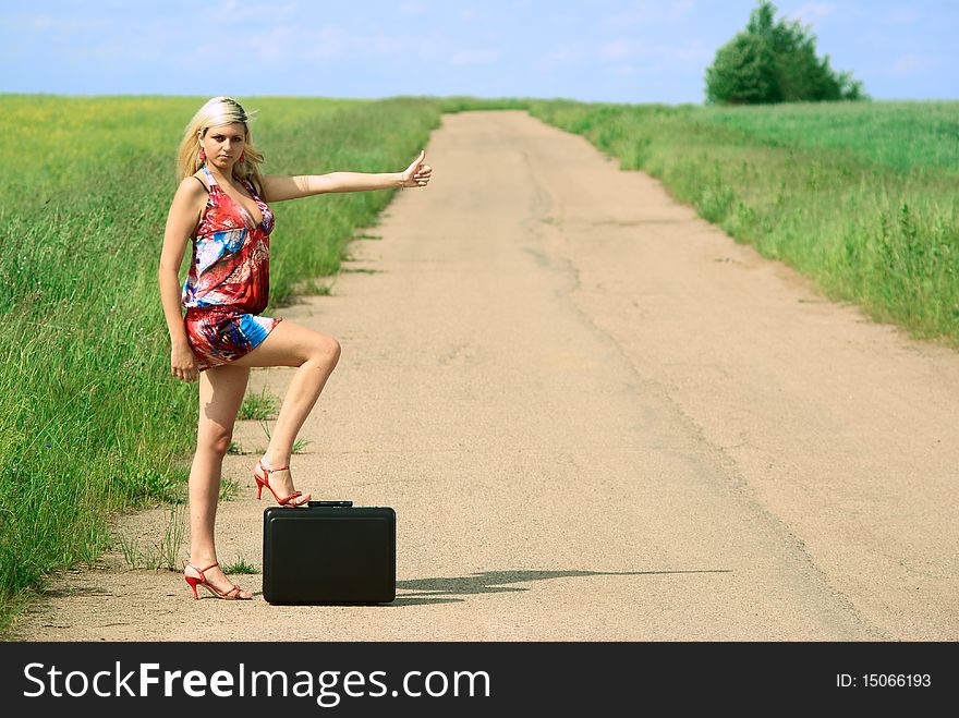 young hitchhiker woman on the road. Outdoor shooting. young hitchhiker woman on the road. Outdoor shooting.