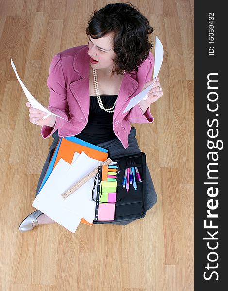 Frustrated business woman sitting on a wooden floor