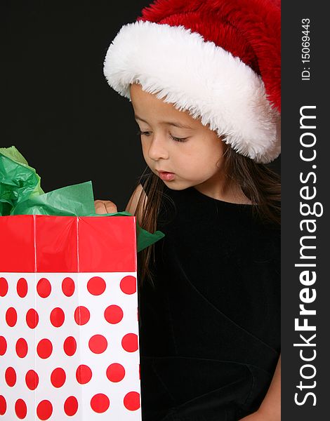 Beautiful young brunette girl looking into a gift bag. Beautiful young brunette girl looking into a gift bag