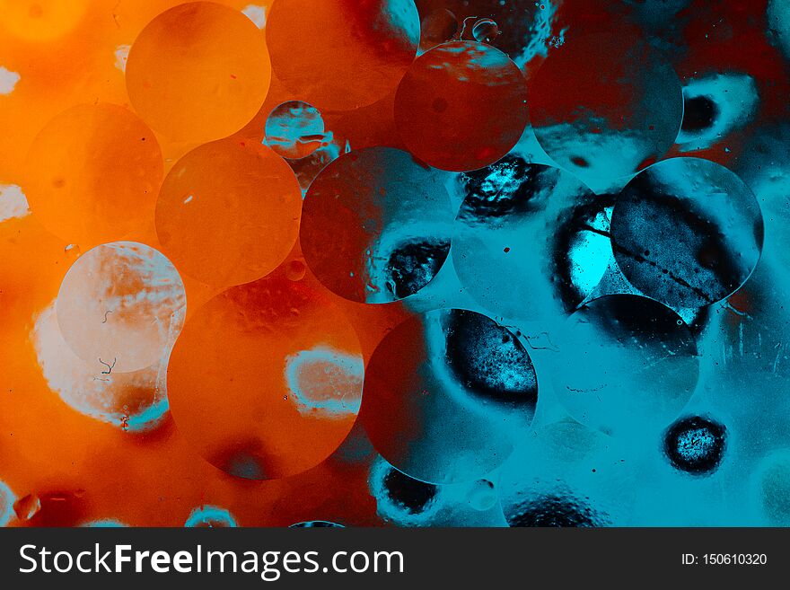 Macro shot of  water-oil emulsion over colored background