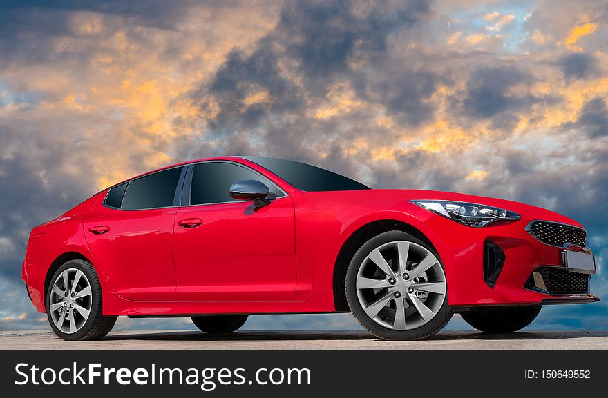 Red car on sunset sky background.