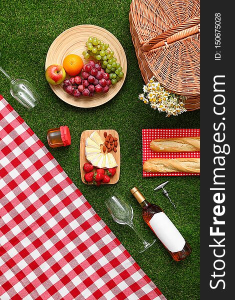 Flat lay composition with picnic blanket, products and wine