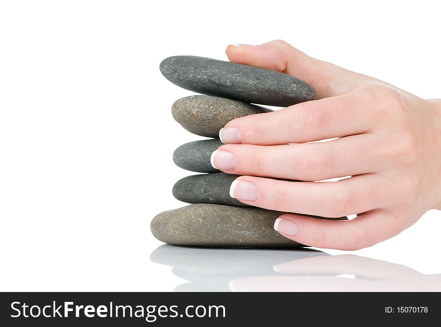 Female hands with french manicure holding pile of stones on white background. Female hands with french manicure holding pile of stones on white background