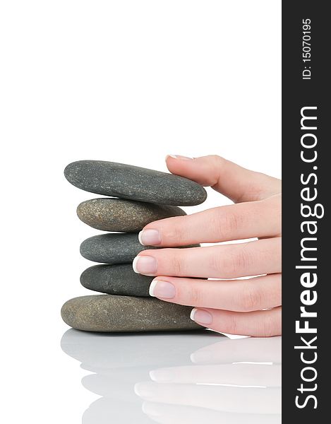 Female hands with french manicure holding pile of stones isolated on white background