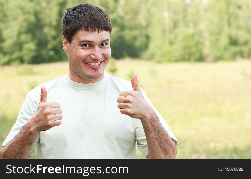 Man gives thumbs up on nature