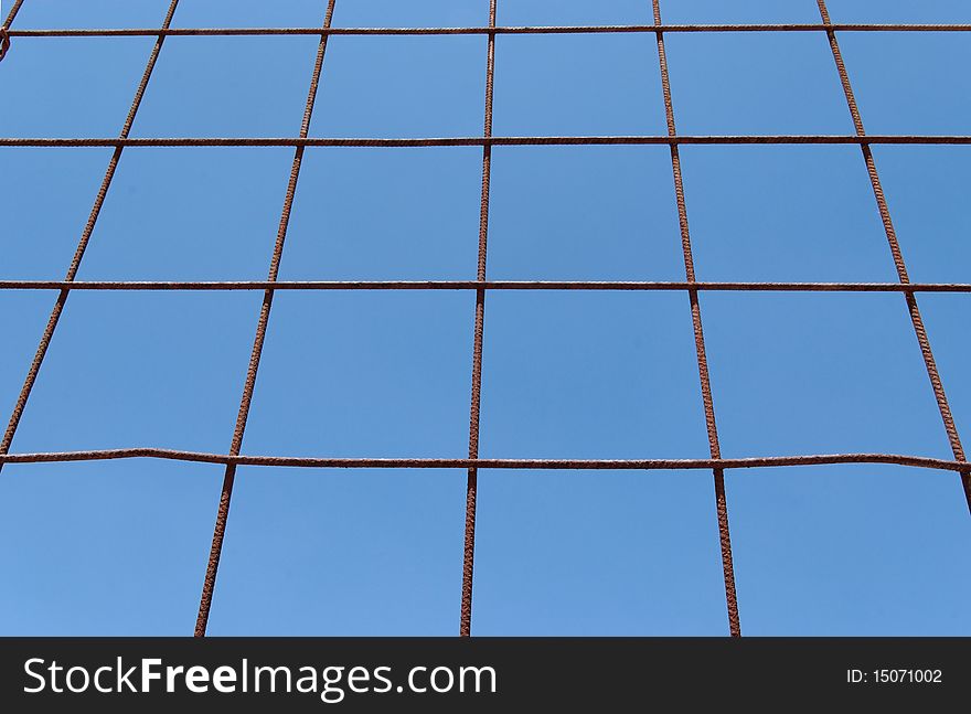 Converging view of rusty lattice on sky background