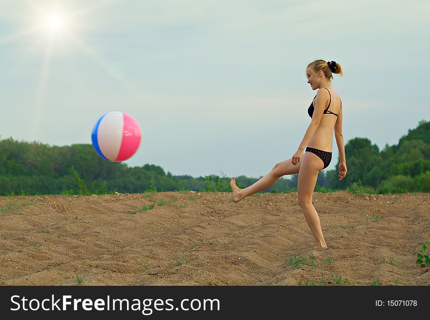 Young girl playing with a ball on the sandy beach. Young girl playing with a ball on the sandy beach