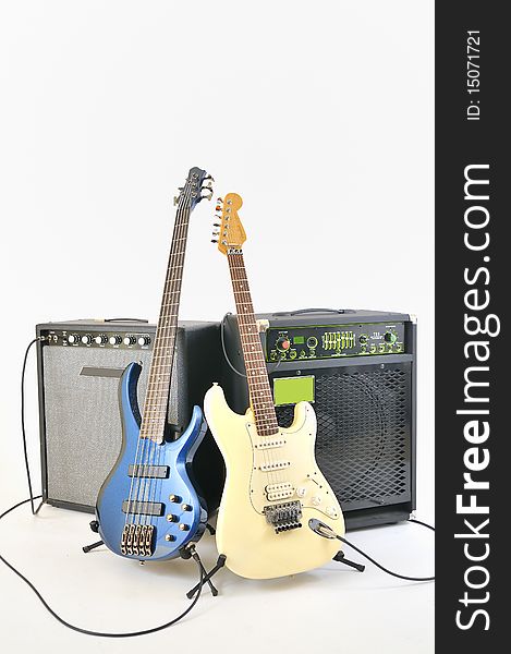 Guitars and amplifiers inside on studio on white background