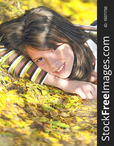 Portrait of a smiling girl lying on leaves