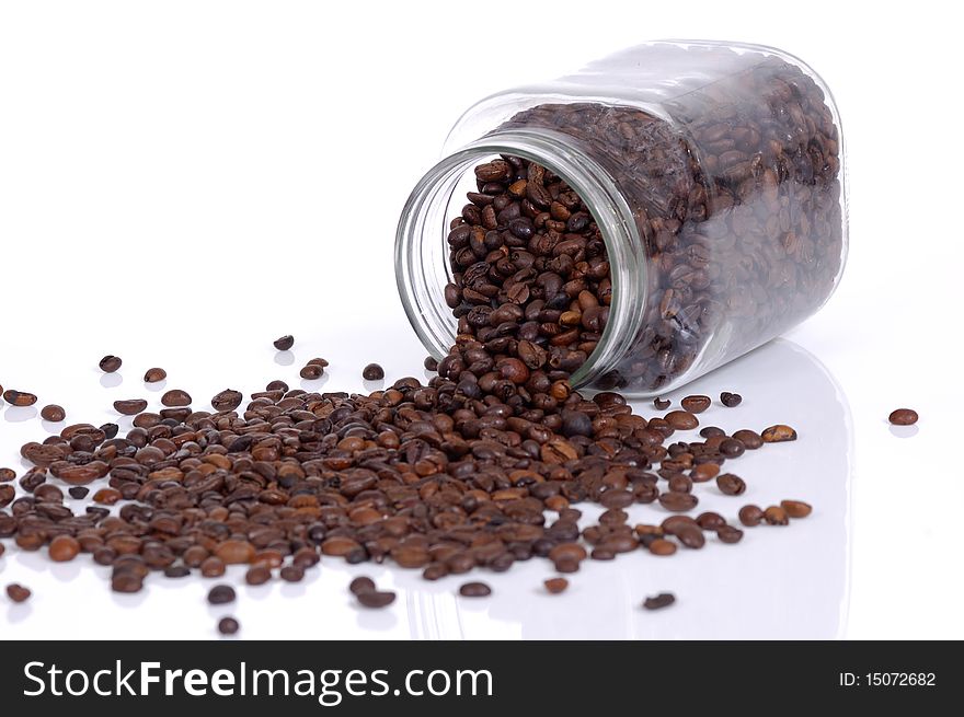 Coffee beans inside glass jar drop on white background. Coffee beans inside glass jar drop on white background