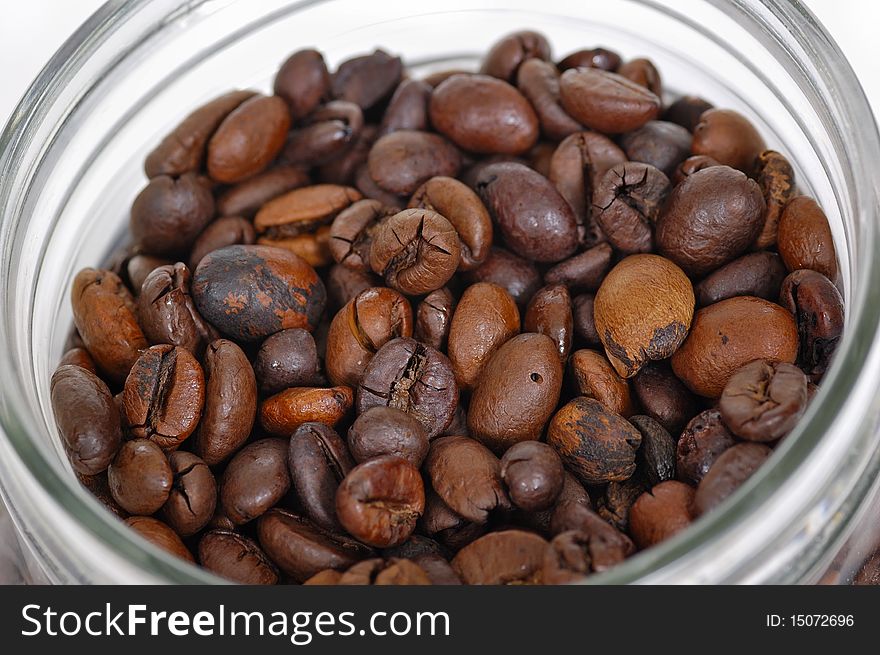 Coffee beans inside glass jar on white background. Coffee beans inside glass jar on white background