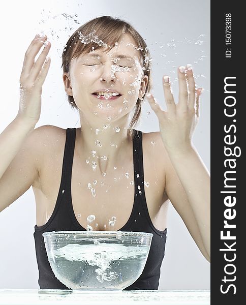 Beautiful young woman washing her face