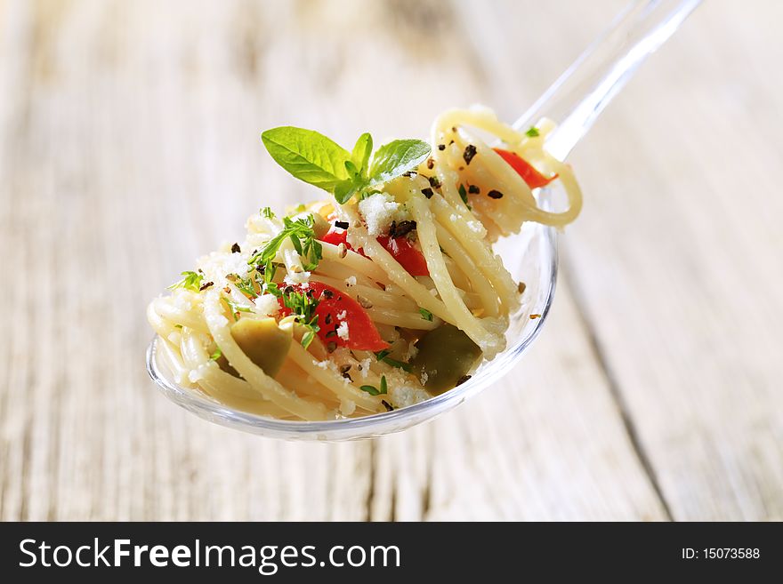 Spaghetti salad sprinkled with parmesan and seasoning