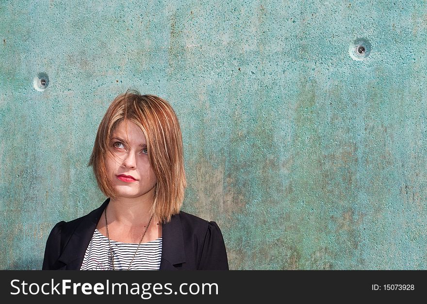 Thoughtful Attractive Blonde Girl By Concrete Wall