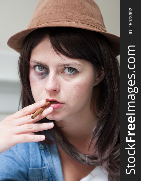Young junkie woman smoking a cigar