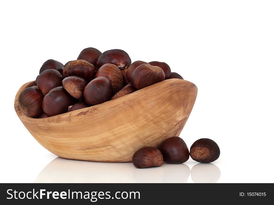 Chestnut collection in an olive wood bowl and scattered, isolated over white background with reflection. Castanea. Chestnut collection in an olive wood bowl and scattered, isolated over white background with reflection. Castanea.