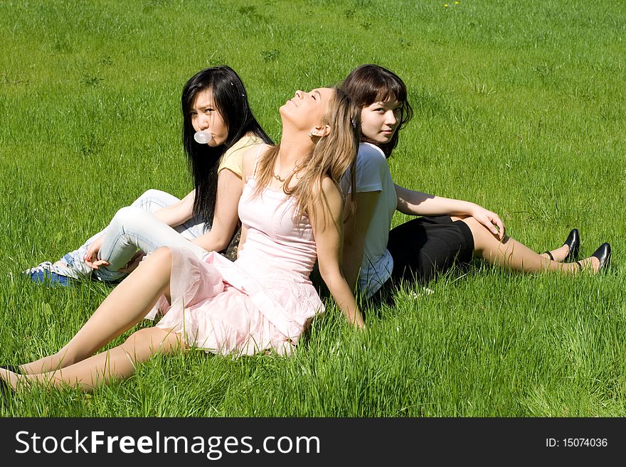 Three girls sitting on grass