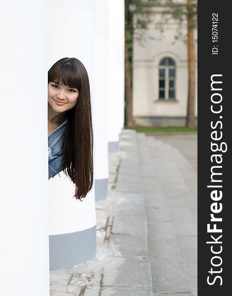 Girl hiding behind column outdoor