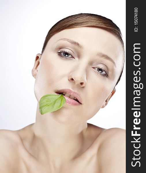 Portrait of woman with basil leaf