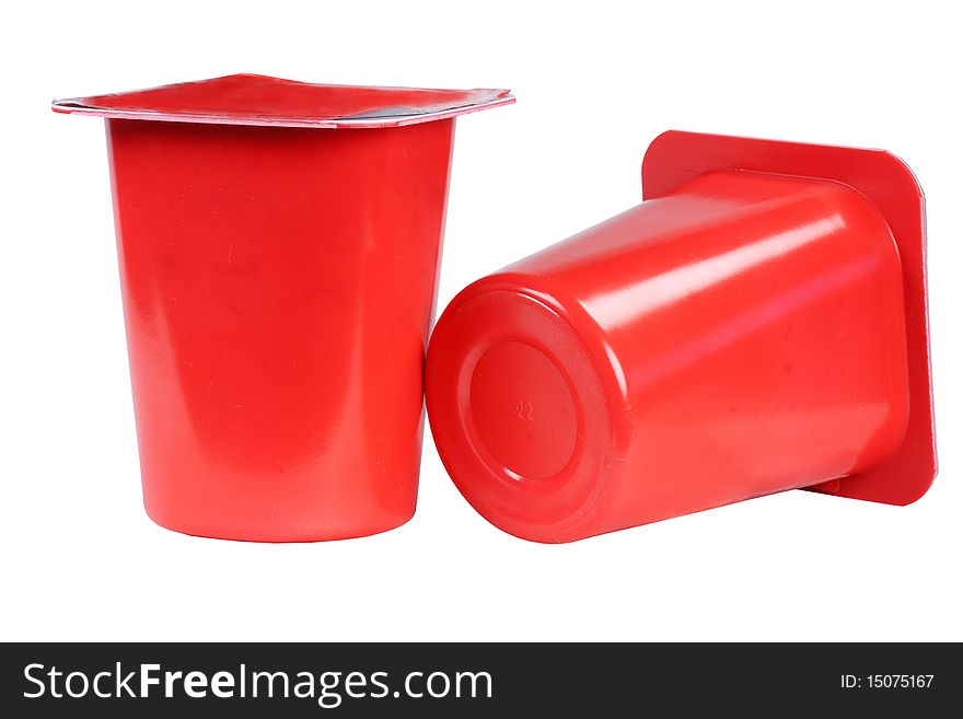 Two plastic glasses with yogurt on white background