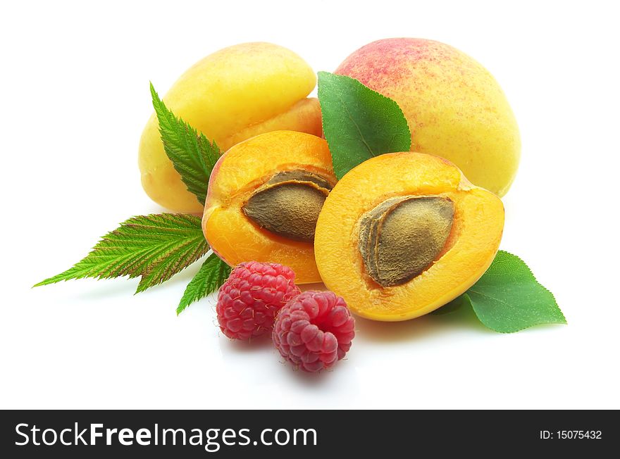 Ripe apricots with stone and raspberry on white background. Ripe apricots with stone and raspberry on white background