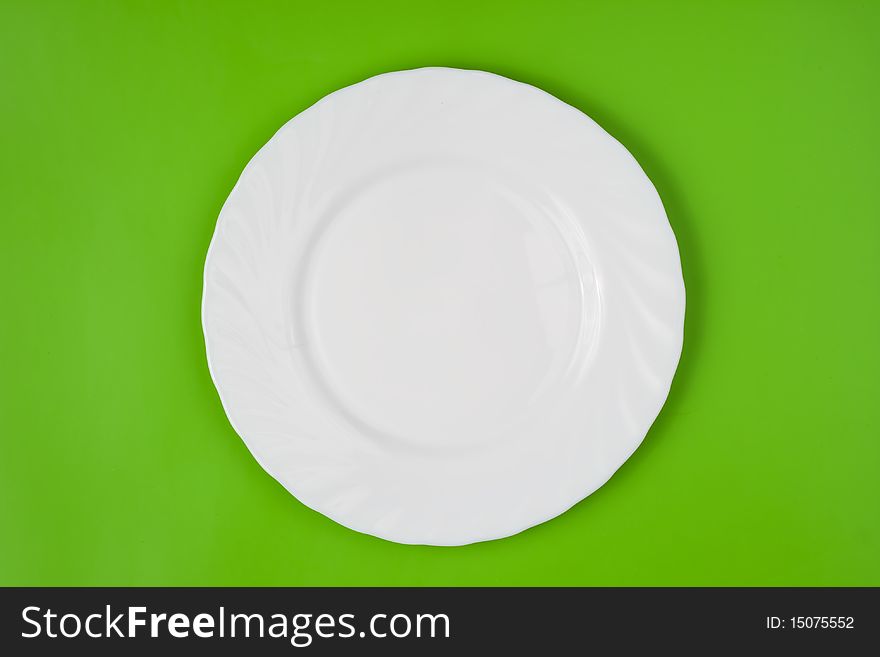 White round plate on green background. White round plate on green background