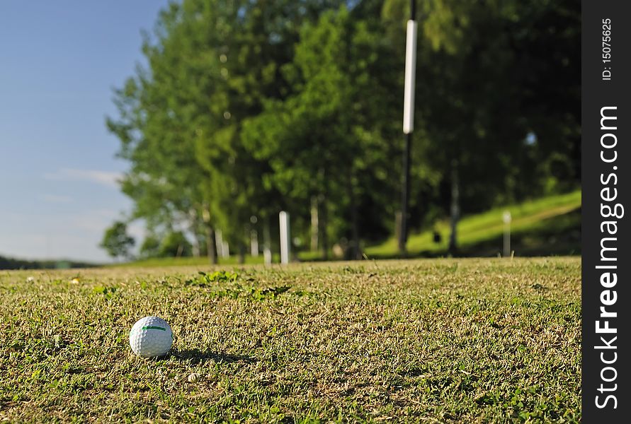 Golf ball close to the flag hole. Golf ball close to the flag hole