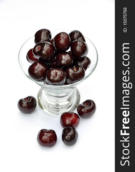 View of cherries in glass dessert bowl over white. View of cherries in glass dessert bowl over white