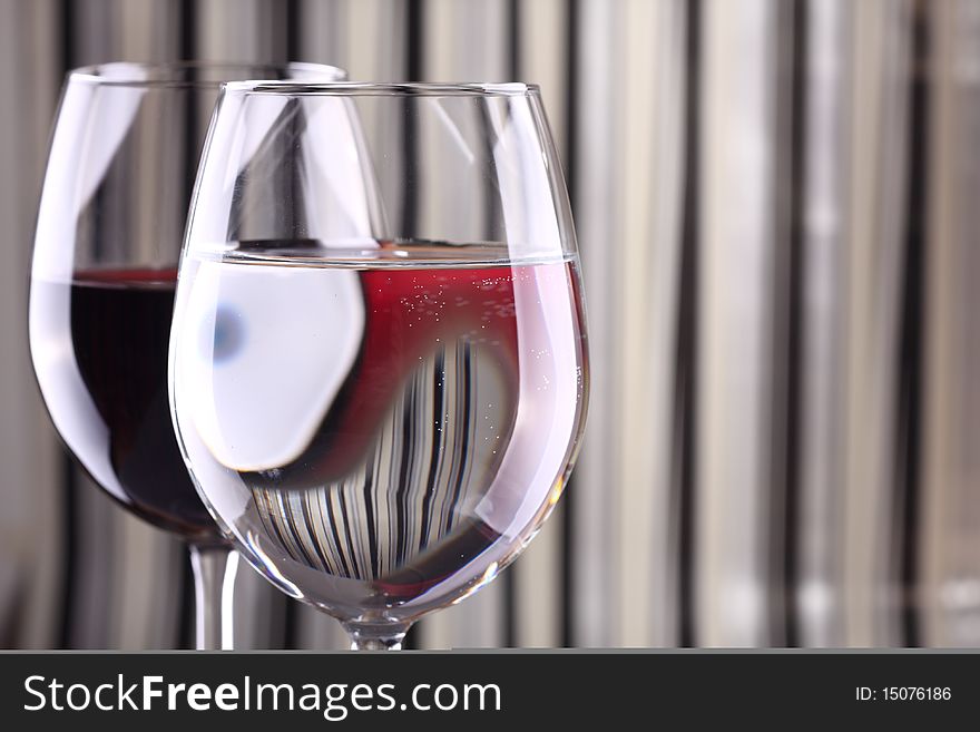 Wine glasses against striped background with dramatic lighting