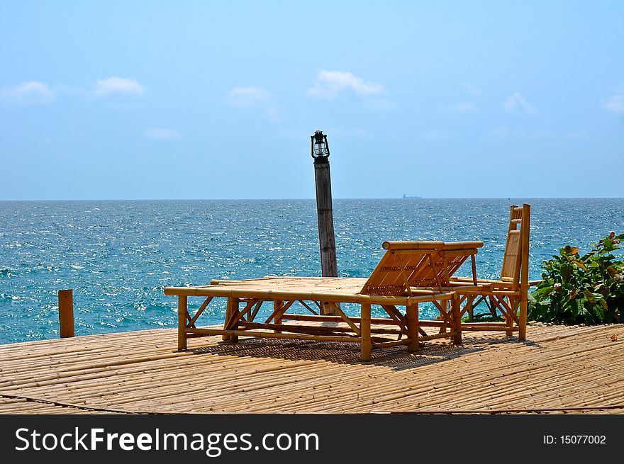 Bamboo chairs near sea with blue sky