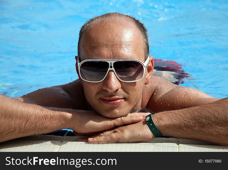 Portrait of a young man near the swimming pool, background. Portrait of a young man near the swimming pool, background