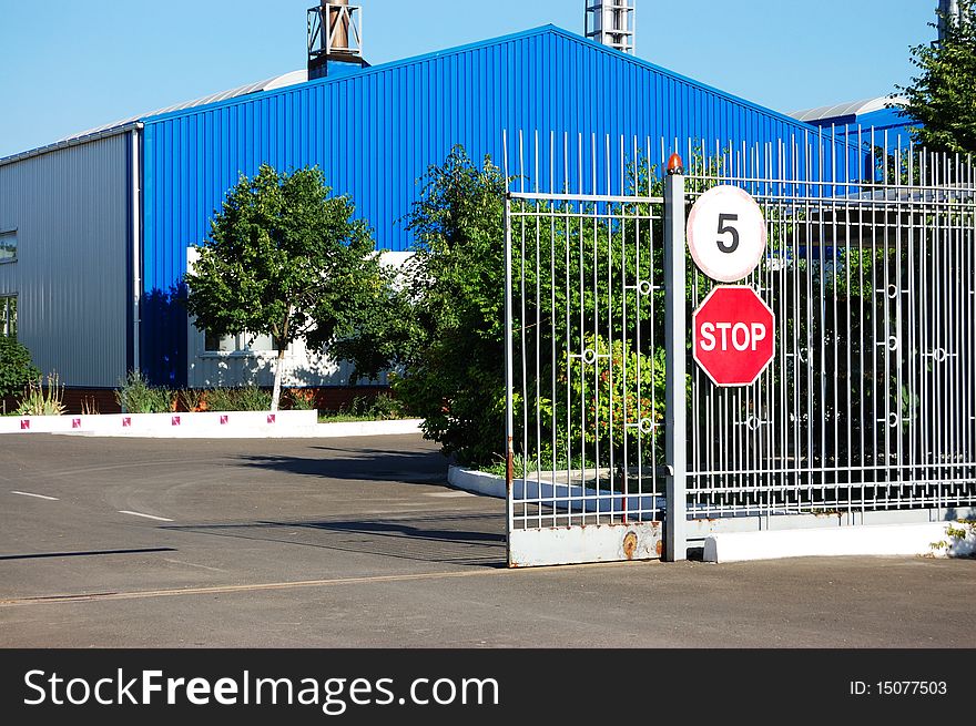 Open metal gate with warning signs