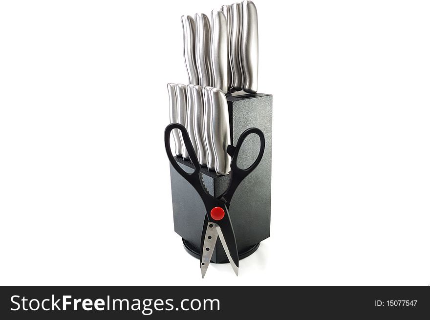 The set of kitchen knifes with the opened scissors is isolated on a white background