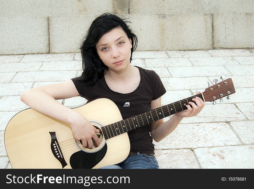 Beautiful Brunette Girl playing guitar