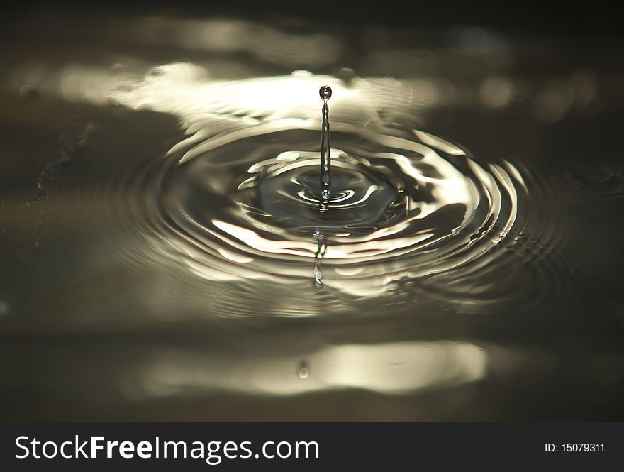 Water drop captured while descending on to the still water surface. Water drop captured while descending on to the still water surface.