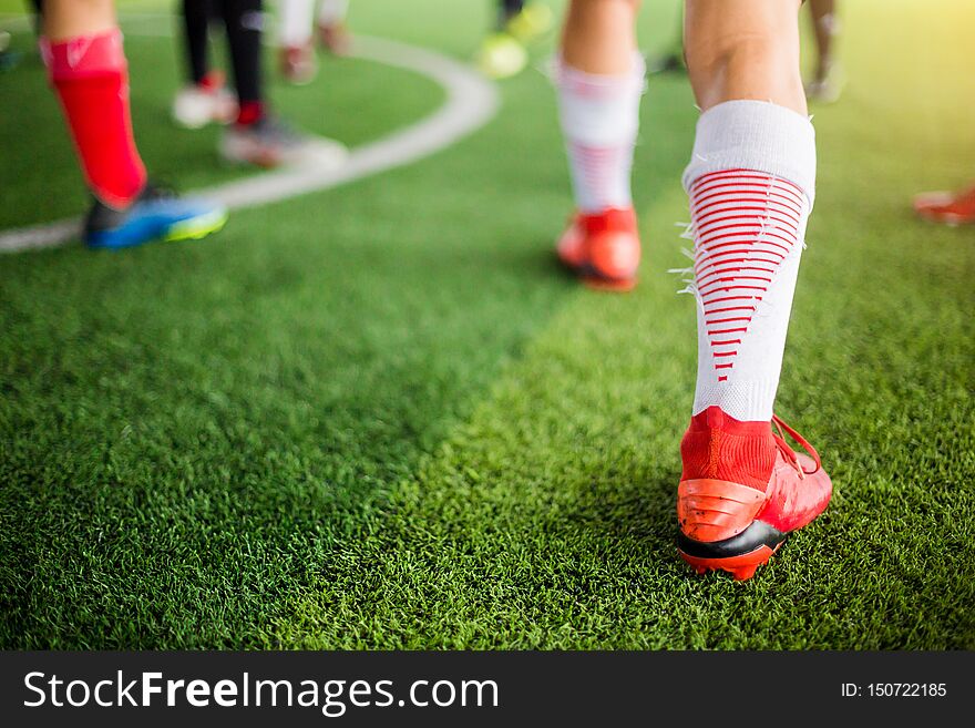 Soccer player Jogging on green artificial turf and stretching their feet. warming up the body and foot