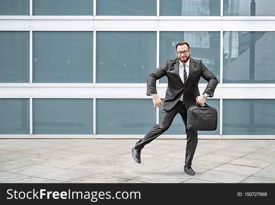 Ridiculous business man in a suit and glasses dancing in the street
