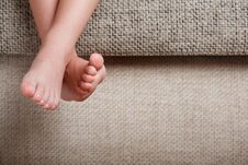 Children`s Legs Close-up Hanging From The Sofa In The Room. Baby Toes While Baby Is Sitting On The Armchair Royalty Free Stock Photos Children`s Legs Close-up Hanging From The Sofa In The Room. Baby Toes While Baby Is Sitting On The Armchair Royalty Free Stock Photos