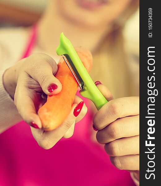 Woman peeling carrot vegetable